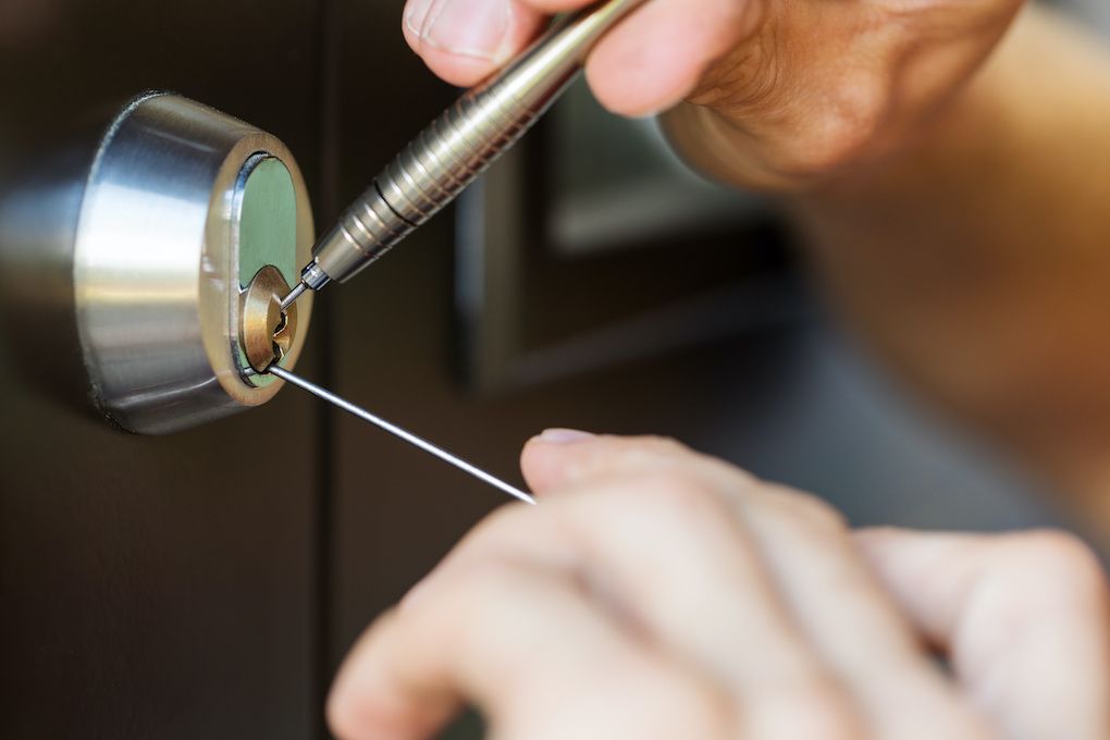 Residential locksmith picking a deadbolt lock on a home entry door in Baltimore, MD