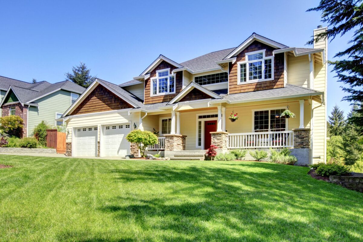 Two-story family home with a front porch and green lawn